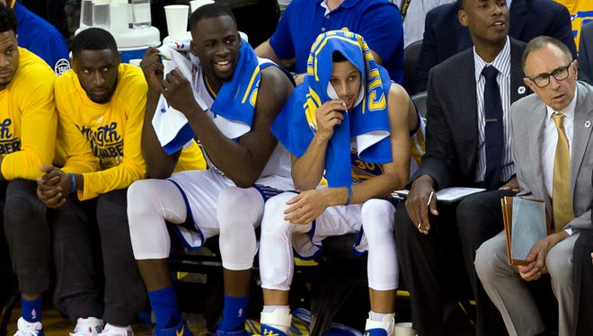 Golden State Warriors forward Draymond Green (23) and guard Stephen Curry (30) on the bench against the Oklahoma City Thunder during the fourth quarter in game one of the Western conference finals of the NBA Playoffs at Oracle Arena.