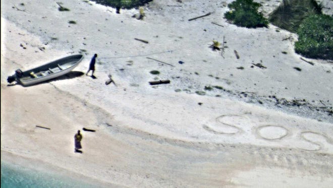 Two mariners stranded for days on an uninhabited island were rescued after writing "SOS" in the sand.