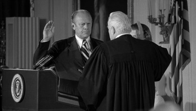 Gerald Ford takes the oath of office after Nixon's resignation on Aug. 9, 1974. Chief Justice Warren Burger administers the oath as Ford's wife, Betty, looks on.