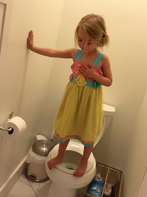 Stacey Feeley's daughter, 3, stands on a toilet in her Traverse City, Mich., home. She was practicing a lockdown drill for her preschool.