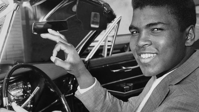 Ali gave a victory sign as he posed behind the wheel of his 1963 convertible after winning his driver's license back in 1963.