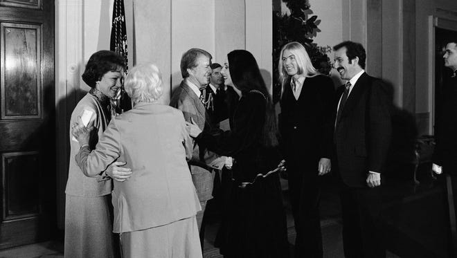 President Jimmy Carter greets singer Cher as Gregg Allman stands second from right during a reception at the White House, Jan. 21, 1977 in Washington held by the Carters for the Georgia Peanut Brigade, a group of campaign workers.