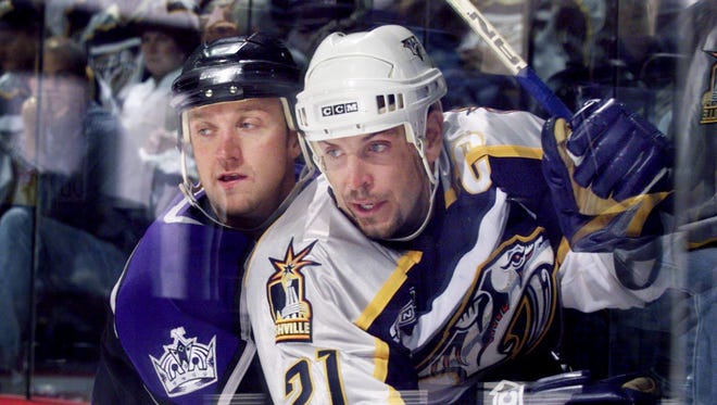 Predators captain Tom Fitzgerald gets hemmed up on the glass by LA Kings Rob Blake during the third period. The Kings won 2-0 in the Predators home opener Oct. 2, 1999.