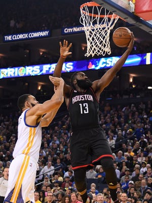 Rockets guard James Harden (13) drives to the basket against Warriors center JaVale McGee (1) during the first quarter.
