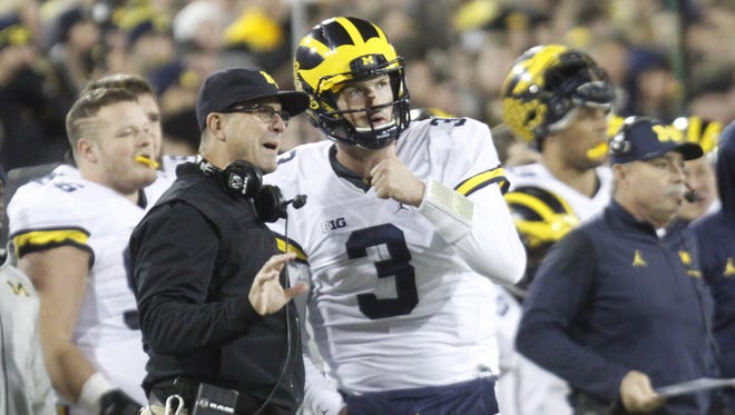 Michigan Wolverines coach Jim Harbaugh talks with quarterback Wilton Speight in the first quarter against the Iowa Hawkeyes on Nov. 12, 2016 at Kinnick Stadium in Iowa City.