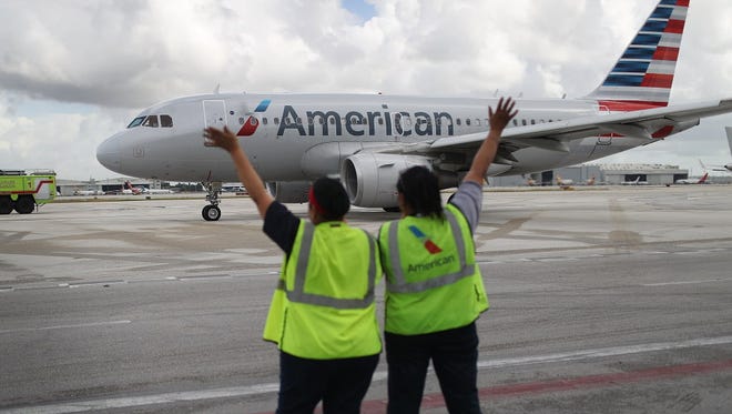 Workers wave as American Airlines Flight 903 prepares for take off in Miami  on Sept. 7, 2016,  for Cuba.