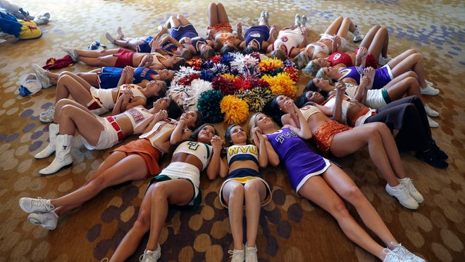 Big 12 cheerleaders lay on the ground during the Big 12 Media Days at Omni Dallas Hotel.