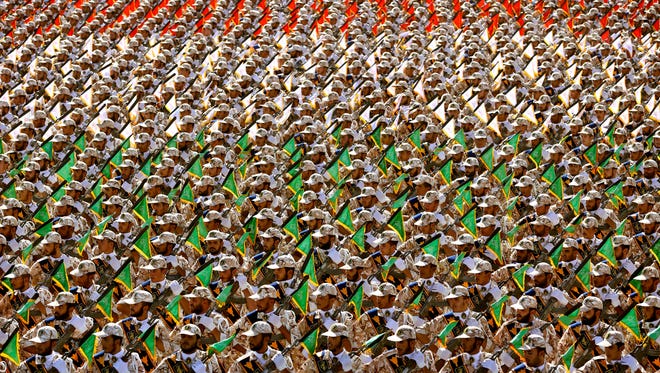 Members of the Iran's Revolutionary Guard march during an annual military parade marking the 34th anniversary of outset of the 1980-88 Iran-Iraq war, in front of the mausoleum of the late revolutionary founder Ayatollah Khomeini just outside Tehran, Iran, Monday, Sept. 22, 2014.