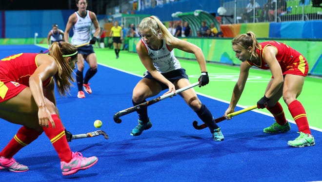 Great Britain forward Sophie Bray battles for the ball with Spain defender Xantal Gine and forward Alicia Magaz during the women's field hockey quarterfinals.