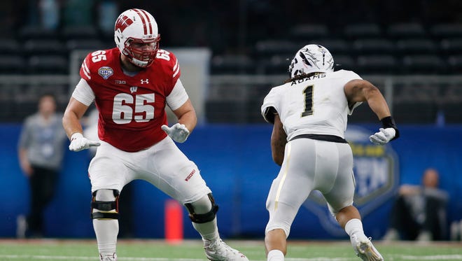 Wisconsin Badgers offensive lineman Ryan Ramczyk (65) blocks Western Michigan Broncos defensive end Keion Adams (1) in the third quarter at AT&T Stadium.