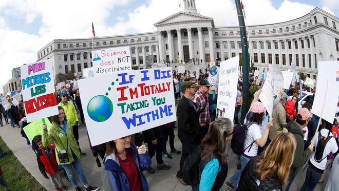 Protesters carry posters during a march for science on April 22, 2017, in Denver.