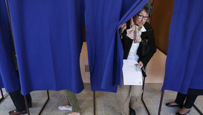 A voter comes out of a polling booth as she prepares to cast her ballot at a polling station in Deauville, France, on April 23, 2017, during the first round of the presidential elections.