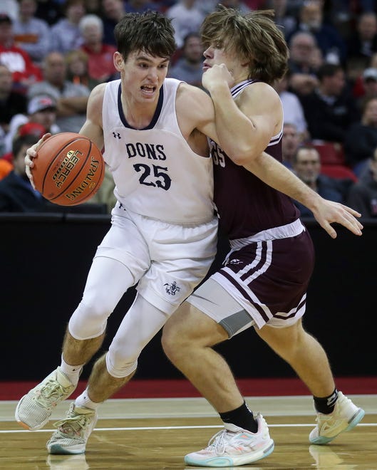 Columbus Catholic High School's Cy Becker (25) drives the baseline against Solon Springs High School's Isaiah Ahlberg (4) in a Division 5 semifinal game during the WIAA state boys basketball tournament on Friday, March 15, 2024 at the Kohl Center in Madison, Wis. Columbus Catholic won the game, 78-65.