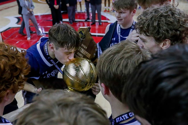 Columbus Catholic High School's Emmitt Konieczny (0) kisses the championship trophy after defeating Abundant Life Christian School in the Division 5 state championship game during the WIAA state boys basketball tournament on Saturday, March 16, 2024 at the Kohl Center in Madison, Wis. Columbus Catholic won the game, 81-75.