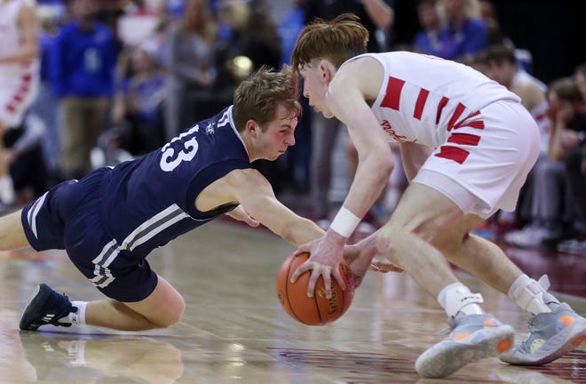 Columbus Catholic High School's Blake Jakobi (13) dives for a loose ball as Abundant Life Christian School's Jacob Koon (2) picks it up in the Division 5 state championship game during the WIAA state boys basketball tournament on Saturday, March 16, 2024 at the Kohl Center in Madison, Wis. Columbus Catholic won the game, 81-75.