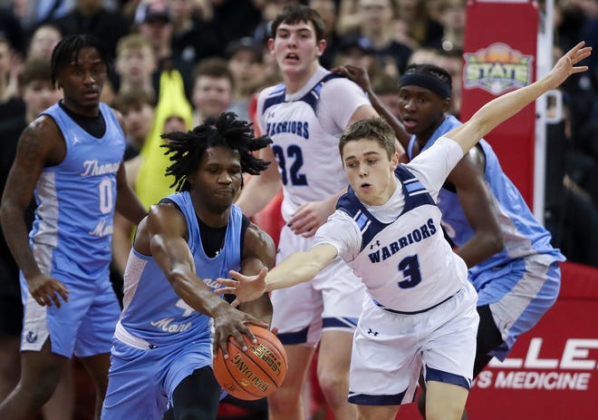 St. Thomas More High School's Amari McCottry (4) and Lakeside Lutheran High School's Ben Krauklis (3) scramble for a loose ball in the Division 3 state championship game during the WIAA state boys basketball tournament on Saturday, March 16, 2024 at the Kohl Center in Madison, Wis.