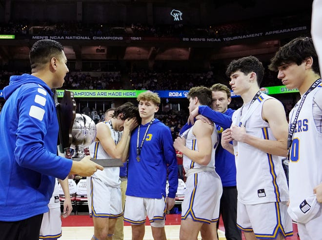 Kenosha St. Joseph head coach Jose Garcia comforts the players as they are defeated by Mineral Point in the WIAA Division 4 boys basketball state championship game on Saturday March 16, 2024 at the Kohl Center in Madison, Wis.