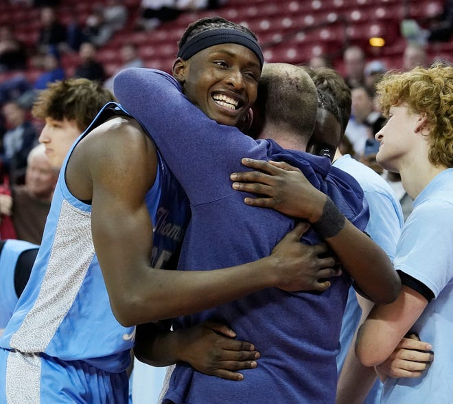 St. Thomas More's Sekou Konneh (25) hugs St. Thomas More head coach Tony Mane Jr. as he is substituted out close to end of the WIAA Division 3 boys basketball state championship game against Lakeside Lutheran on Saturday March 16, 2024 at the Kohl Center in Madison, Wis.