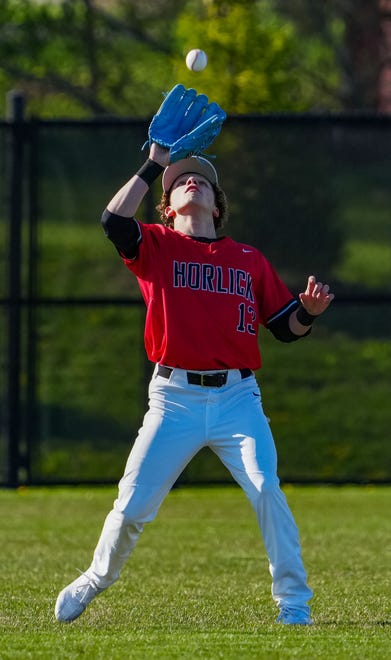 Racine Horlick center fielder Colin Repa (13) pulls in a fly during the game at Oak Creek, Friday, April 19, 2024.