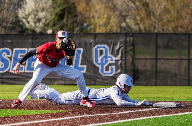 Oak Creek's Reece Doyle (24) dives back to first as Racine Horlick's Cole Weisenbeck (9) waits on the throw during the game at Oak Creek, Friday, April 19, 2024.