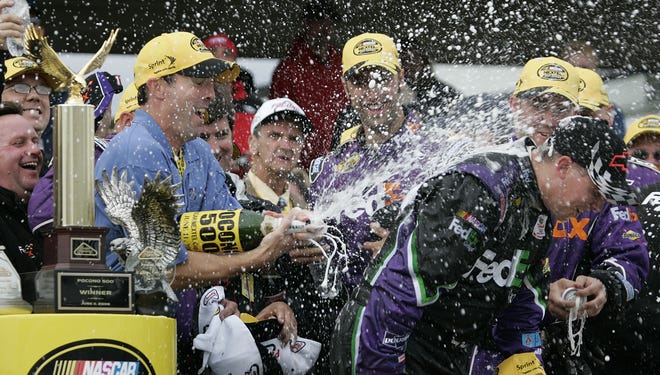 Team owner J.D. Gibbs, left, sprays driver Denny Hamlin with champagne after Hamlin won his first Nextel Cup race, the Pocono 500, on June 11, 2006, at Long Pond, Pa.