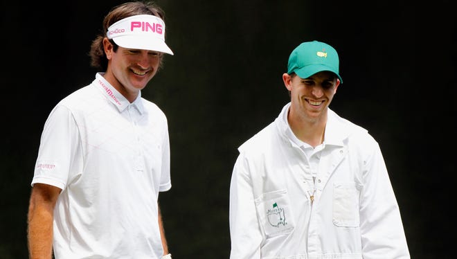 Denny Hamlin, right, looks on as he caddies for Bubba Watson during the Par 3 Contest prior to the start of the 2012 Masters at Augusta National Golf Club on April 4, 2012.